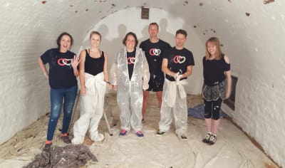 Group of people volunteering by painting a bunker