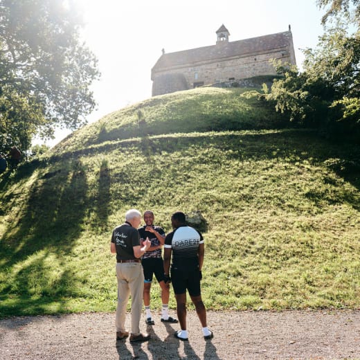 Three people stand infront of a chapel
