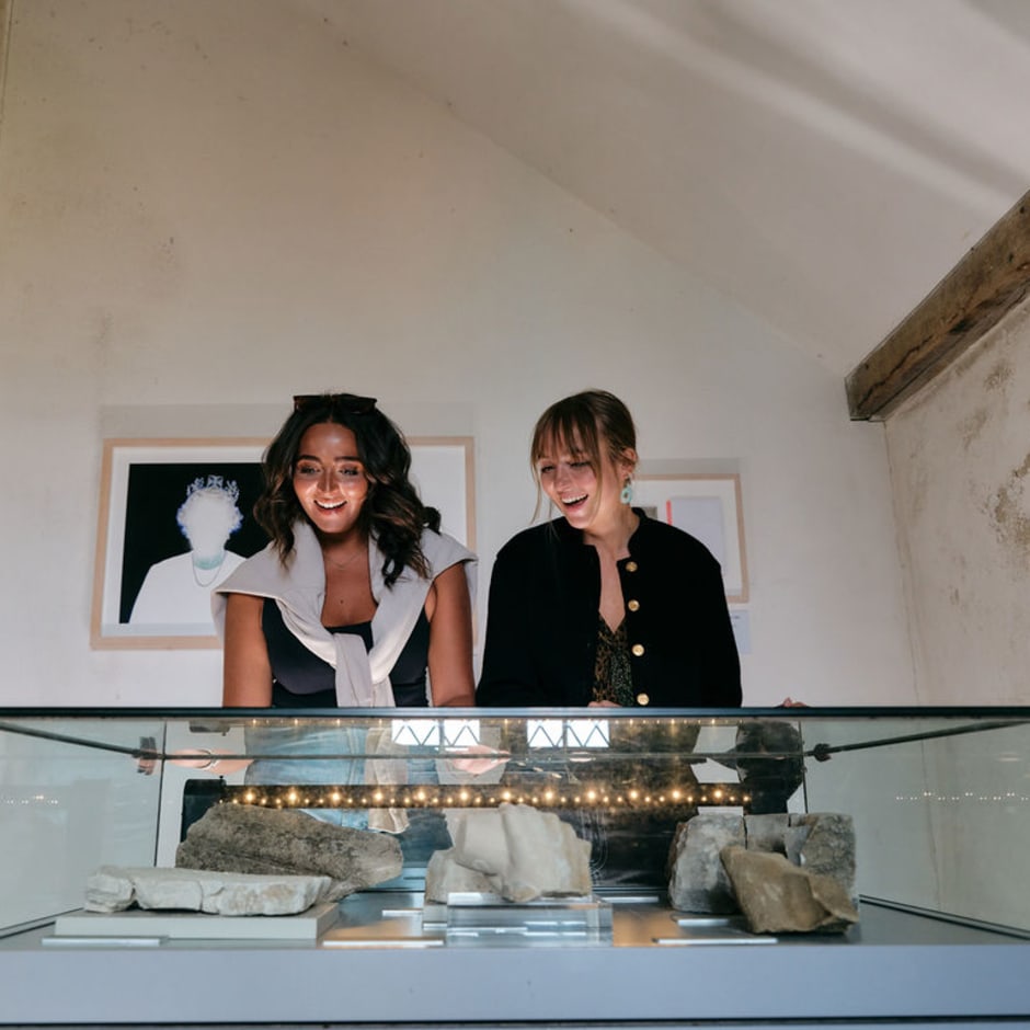 Two people look closely at an exhibition piece