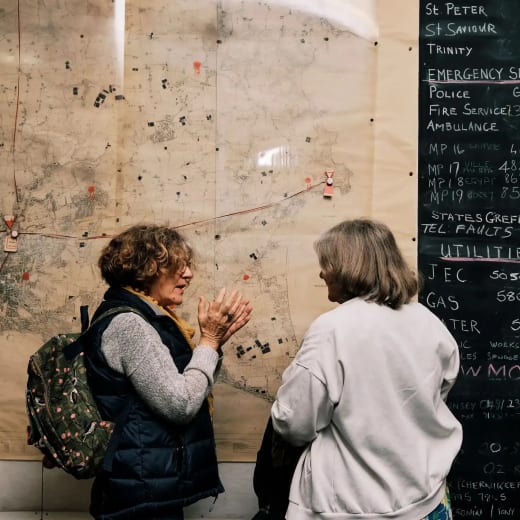 Cold War Bunker women stand by large wall map of Jersey