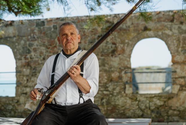 Man polishes fashioned rifle