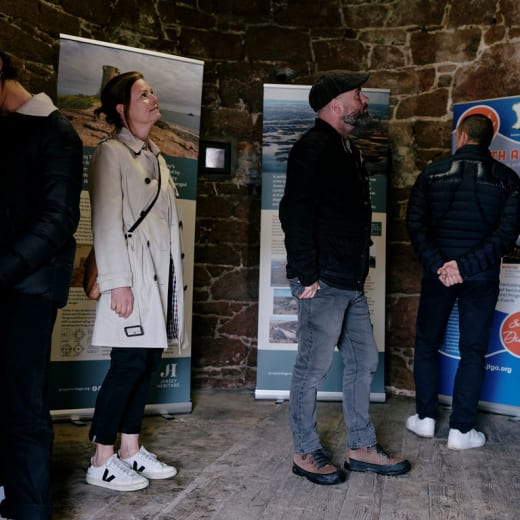 group stand in a stone building reading an exhibition