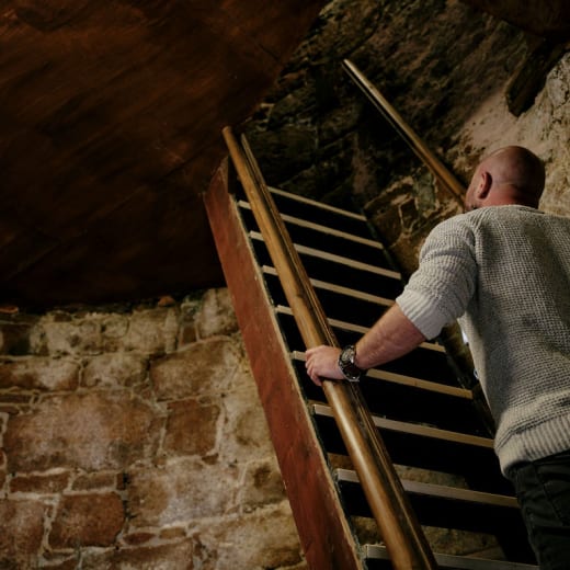 Man climbs steep wooden staircase