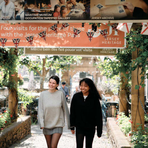 Two people walk under banners