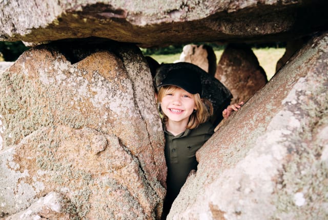 Faldouet Dolmen child poses with stones