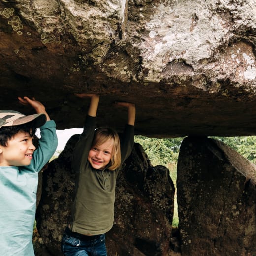 Faldouet Dolmen children pretend to hold up large cap stone