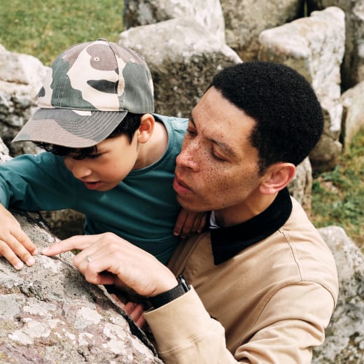 Faldouet Dolmen man and child look closely at a large standing stong