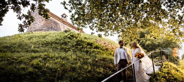 La Hougue Bie Bride and Groom Pose on Stairs with Chaple in Background