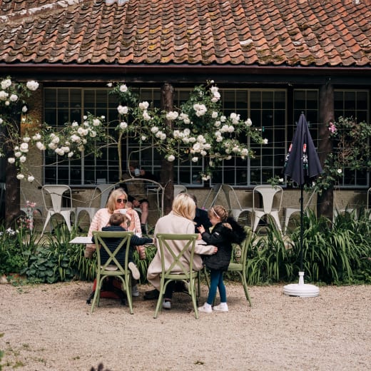 Family sit at picnic bench