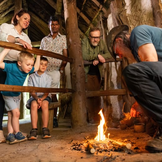 Group of people watch someone light a fire