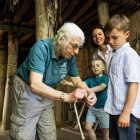 Person shows a young boy how to tie a knot