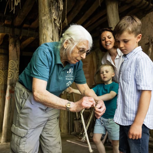 Person shows a young boy how to tie a knot