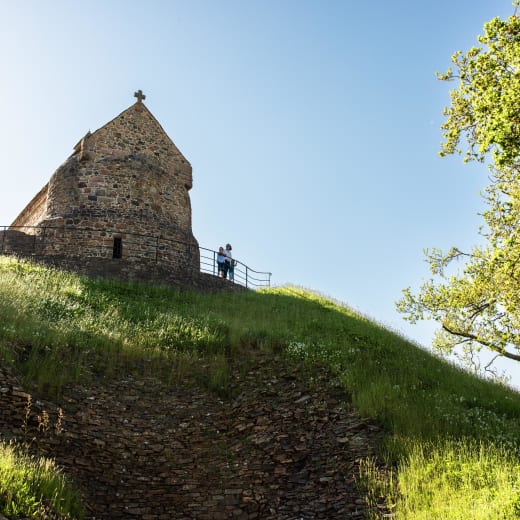 People stand in front of an old stone church
