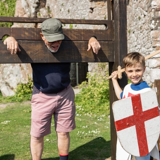 a boy in costume puts a man in the stocks