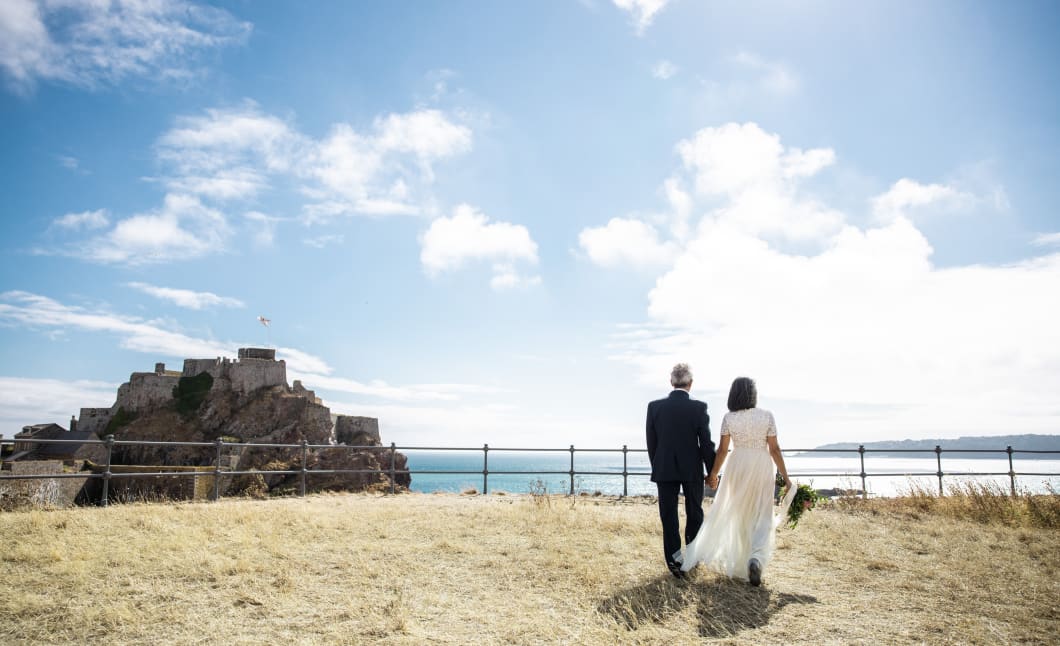 Man and Woman getting married walk towards Elizabeth Castle