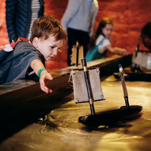Maritime Museum child plays with water exhibit