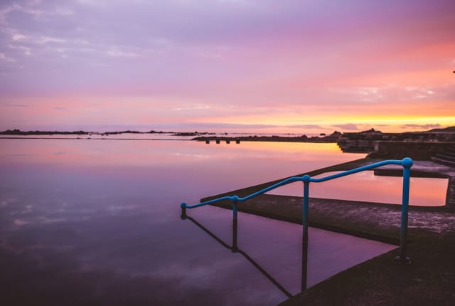 A sunset sea with steps down to the water