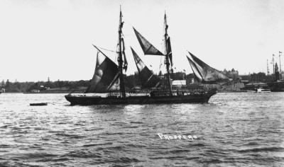 A black and white photo of a ship in the water.