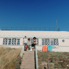 Family with surf boards sit at the top of some steps