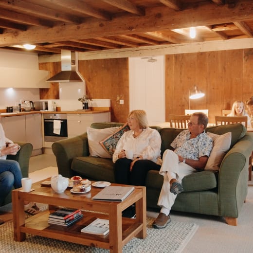 Family site on green sofas in rustic living room