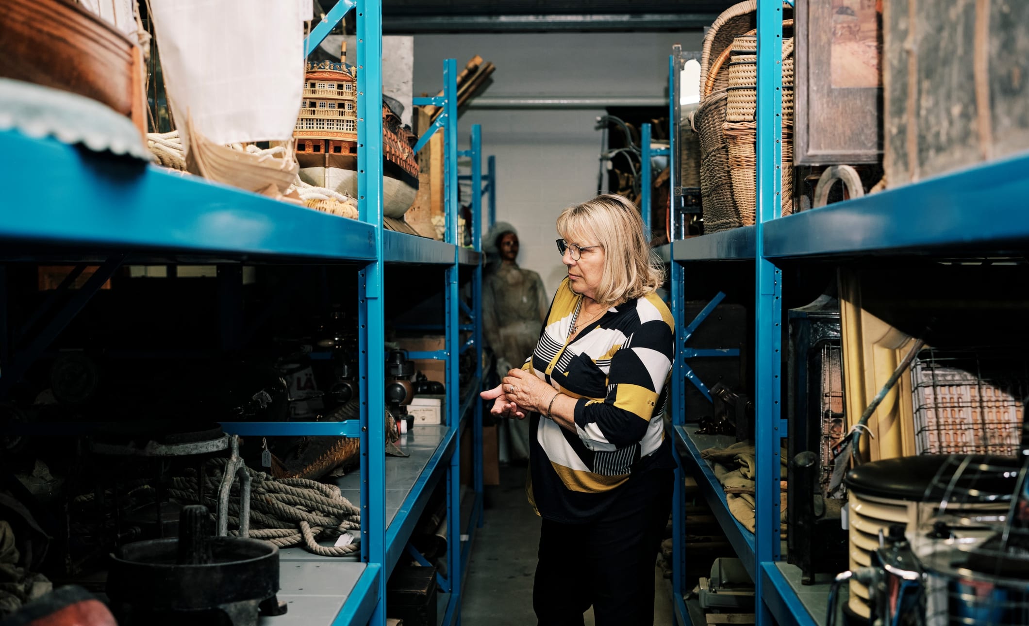 Sir Francis Cook women stands amongst lots of items