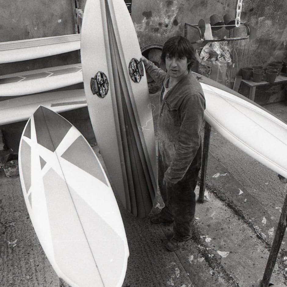 A black and white photo of a person with two surf boards